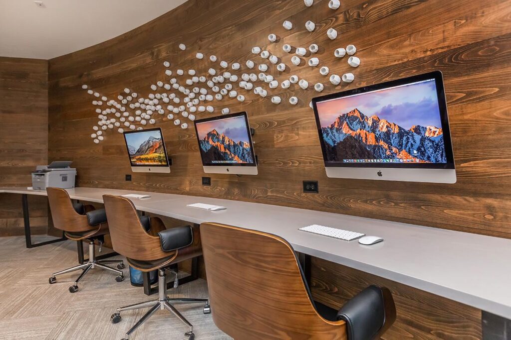 Computer lab area with MAC computers, computer chairs, and printer