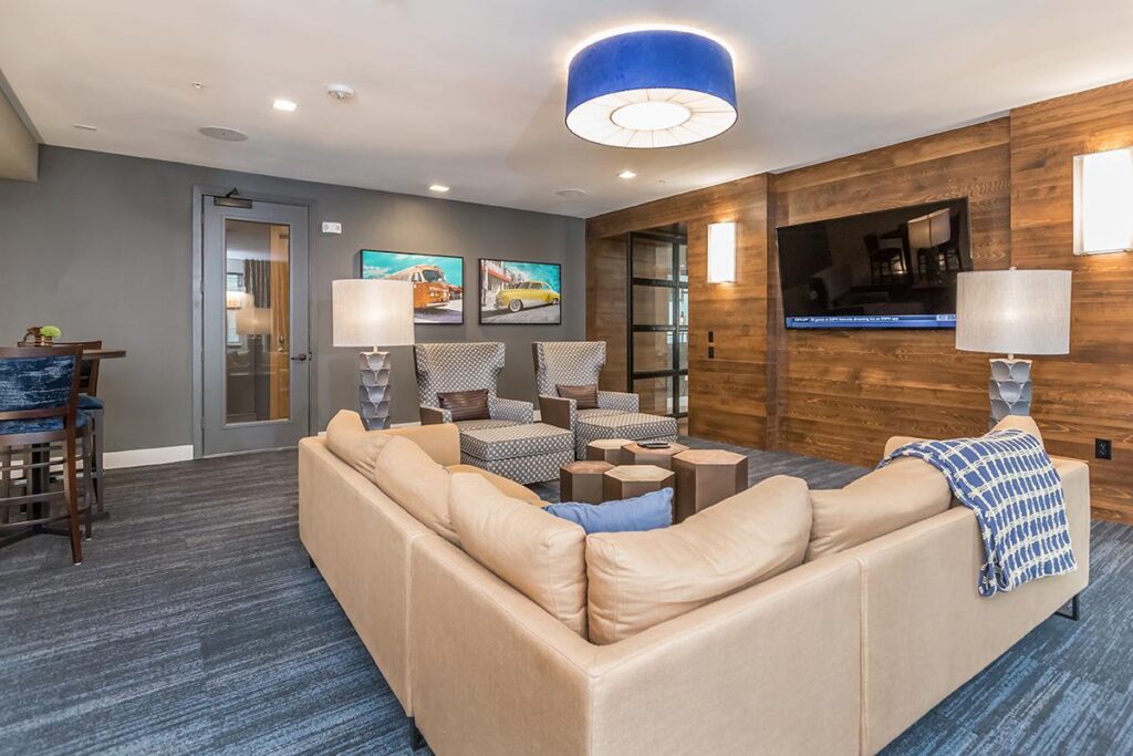 Clubhouse interior with variety of seating, television, and carpet flooring