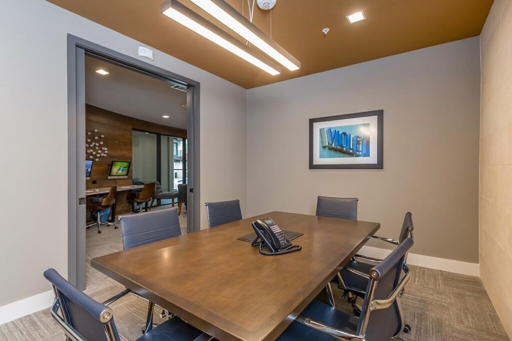 Conference room area with table seating, telephone, and carpet flooring