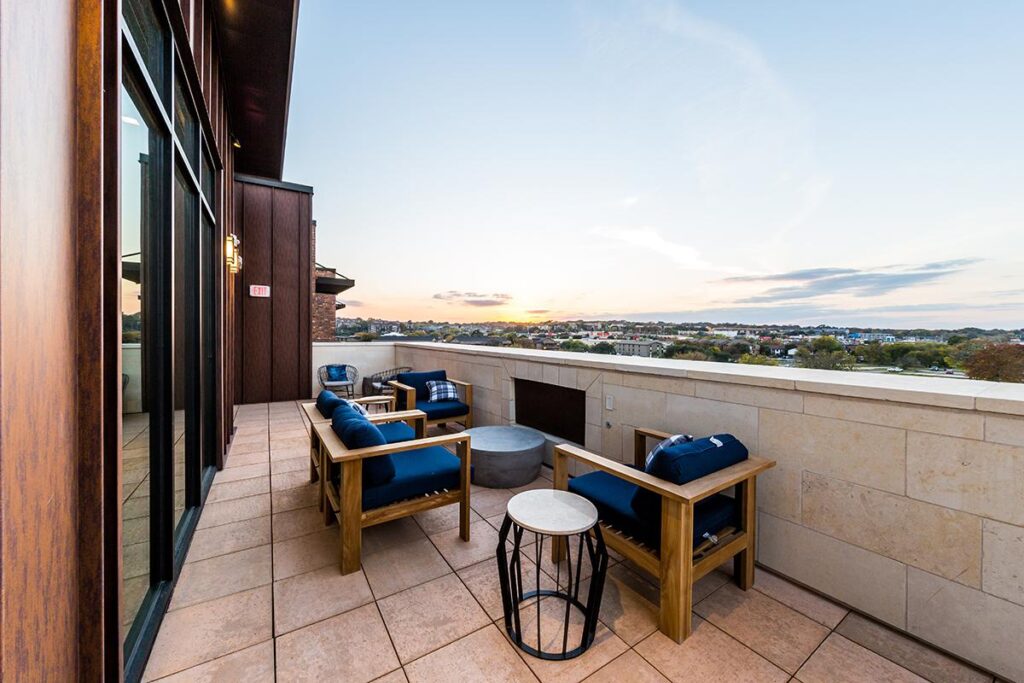 Outdoor rooftop deck with couch seating and firepit